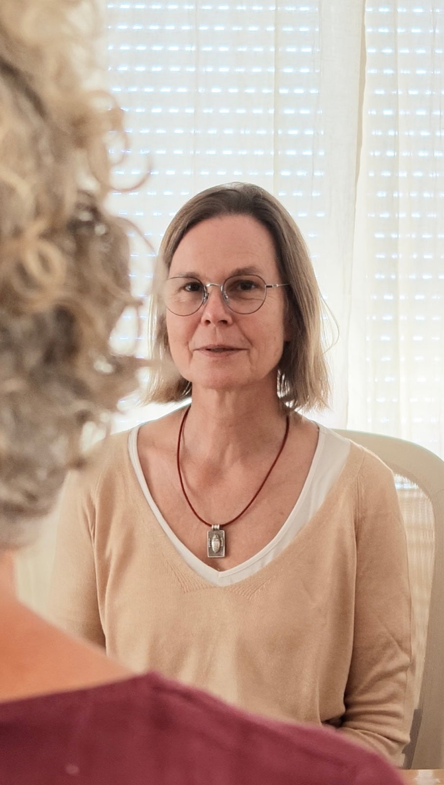 Annette Hemmerich im Gespräch, im Gegenlicht vor einem Vorhang