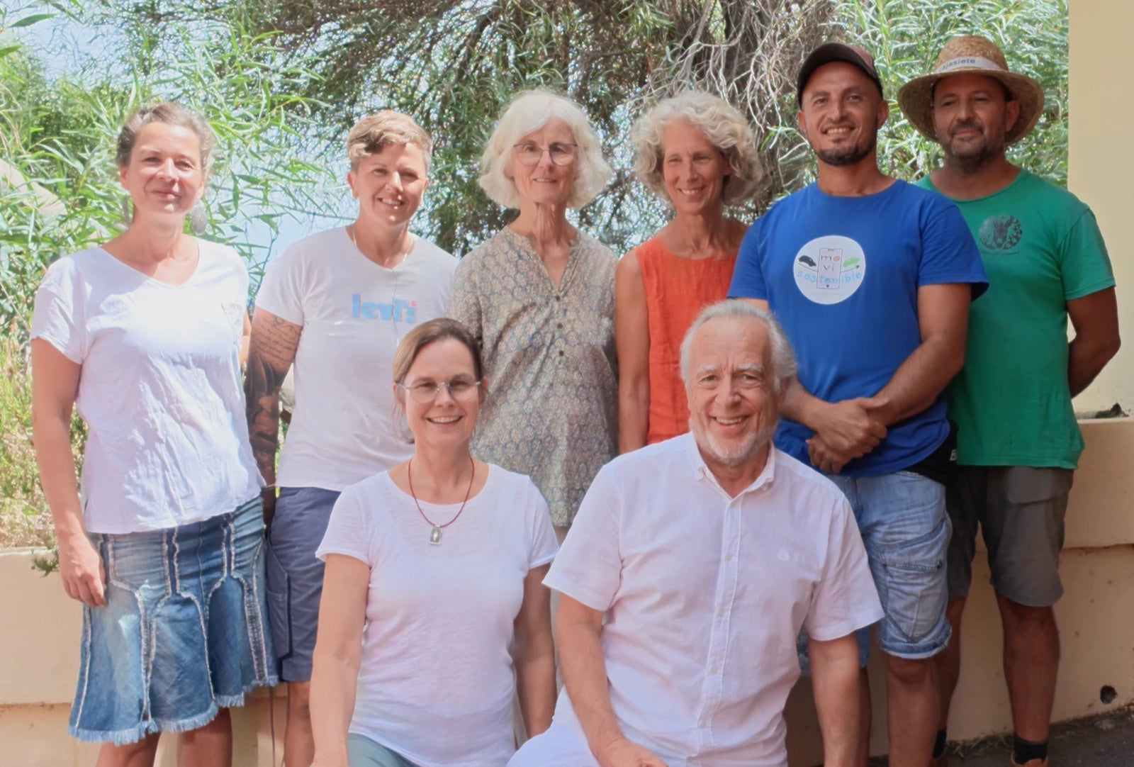 Die Crew des Centro Eridanos, acht Menschen vor grünen Bäumen